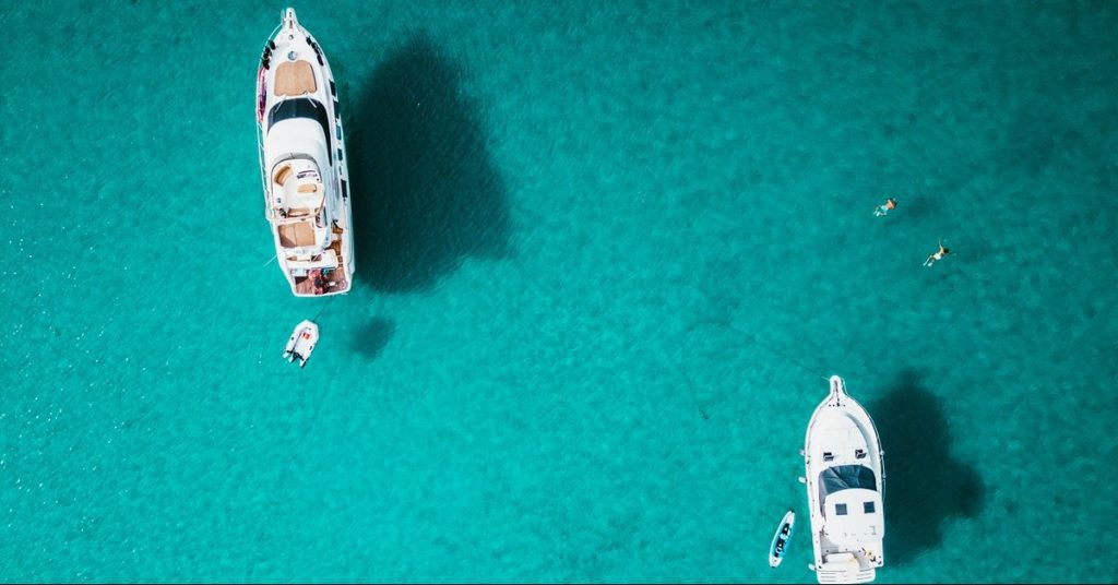 Two yachts on the blue water from above, yacht engines