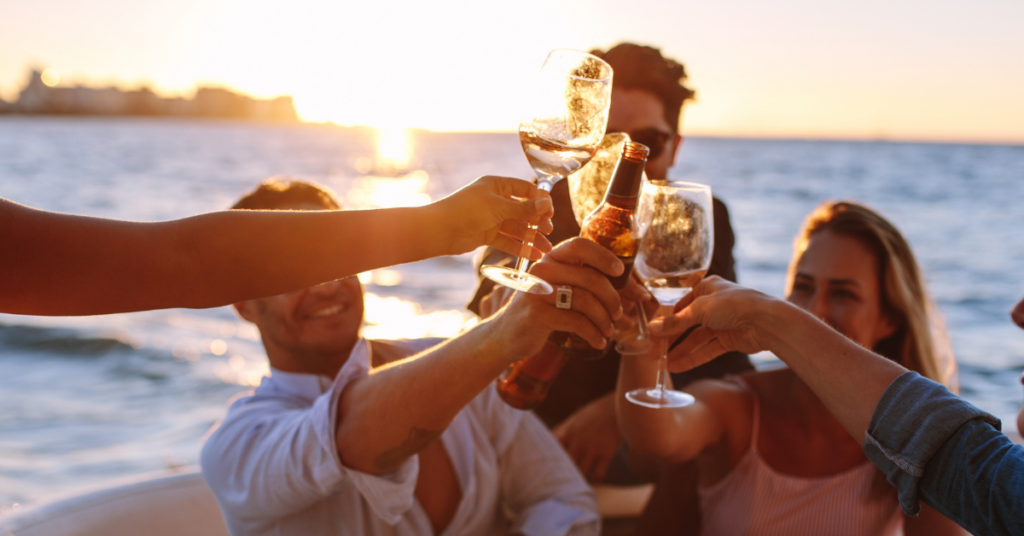 people on a boat drinking wine with the sunset in the background