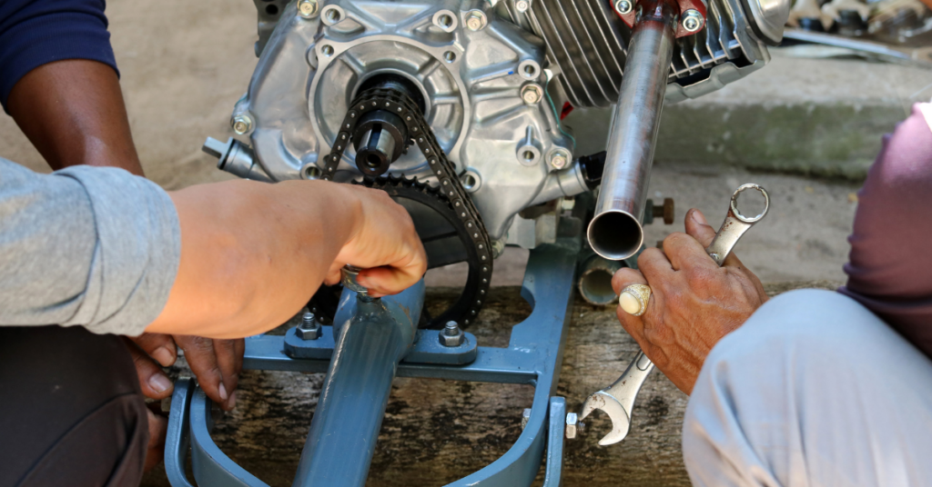 Three people working to fix a mairne engine.